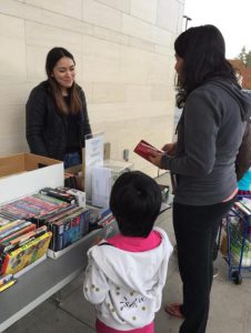 A parent and child buying books at a Santa Clara City Library Foundation and Friends book sale at the Northside Library