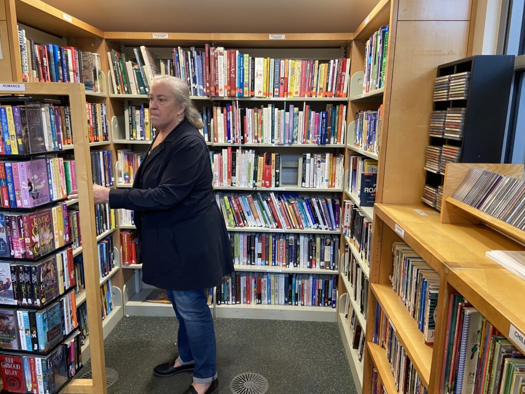 a photograph of a person browsing in a small used bookstore.