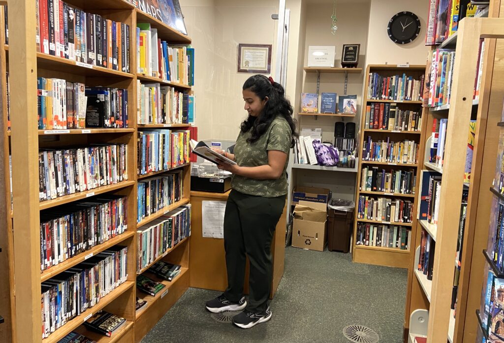 a photograph of a customer shopping at the Friends of the Santa Clara City Library bookstore