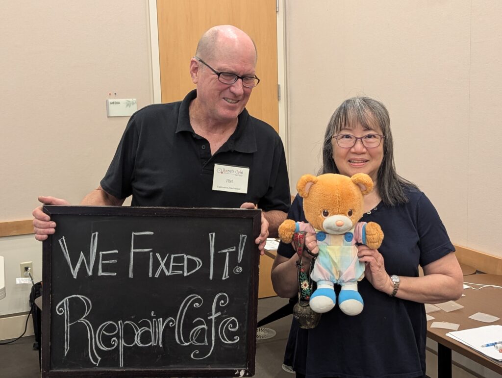 Two people who fixed a teddy bear as part of the Repair Cafe at Santa Clara City Library